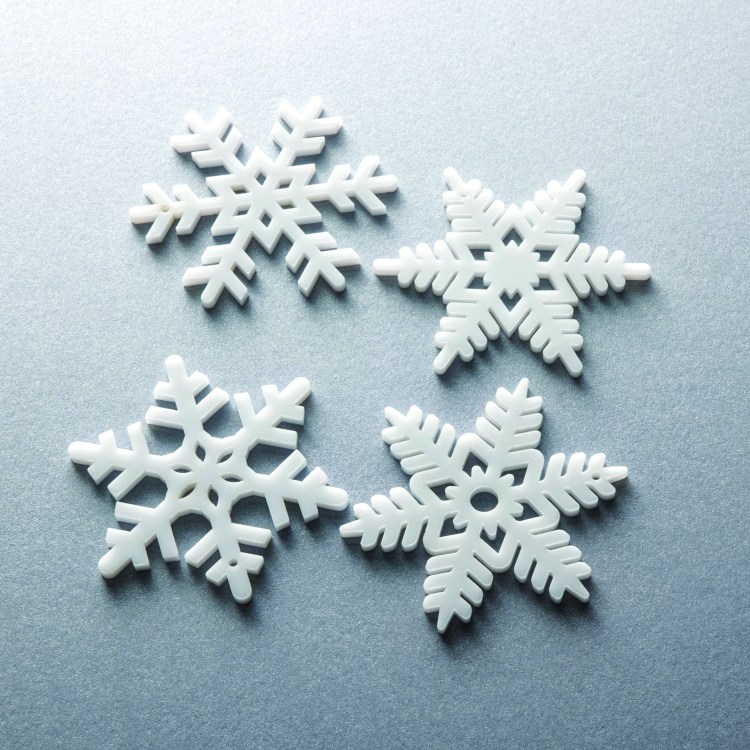 A set of laser cut white acrylic Christmas ornaments.